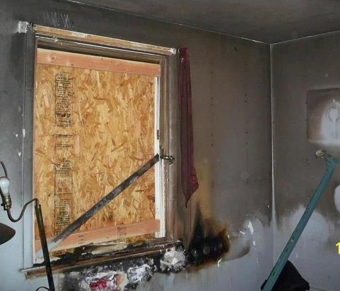 Boarded up window in a home with substantial fire damage