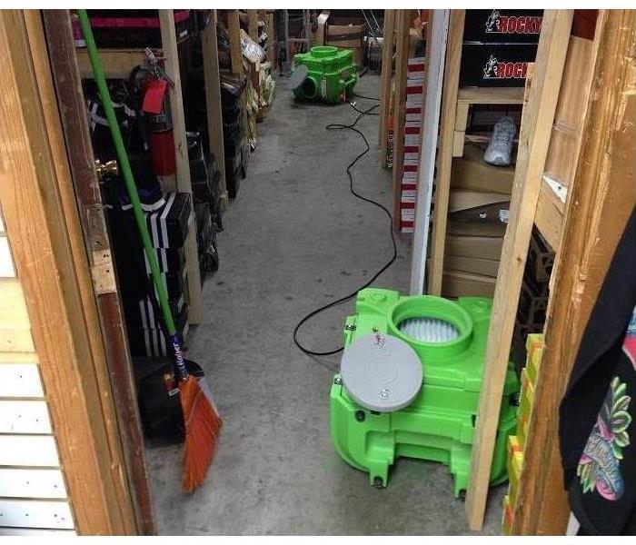 Air scrubber placed on the floor of a storage room in a retail store